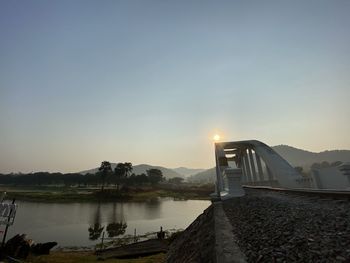 Bridge over lake against sky during sunset