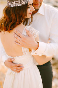 Midsection of couple embracing outdoors