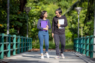 Full length of young woman standing on footpath