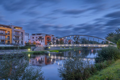 Bridge over river in city against sky