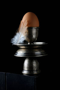 Close-up of feather on table against black background