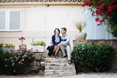 Portrait of couple sitting against building