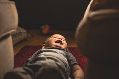 High angle view of baby boy lying on carpet