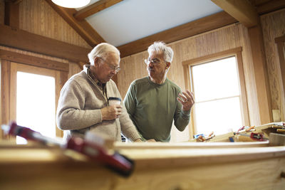 Colleagues working on canoe in workshop