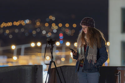 Woman standing in illuminated city at night