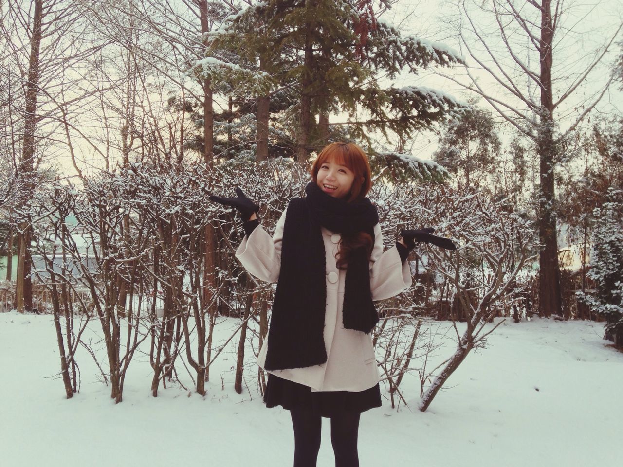 winter, snow, cold temperature, looking at camera, lifestyles, portrait, person, young adult, front view, standing, season, leisure activity, tree, young women, casual clothing, warm clothing, three quarter length, smiling