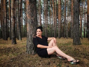 Portrait of young woman sitting in forest