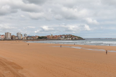 Scenic view of beach and buildings against sky