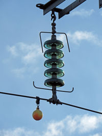 Low angle view of lighting equipment hanging against sky