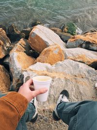 Low section of man holding coffee cup