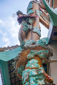 Low angle view of statue against building against sky