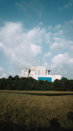 Houses on field against sky