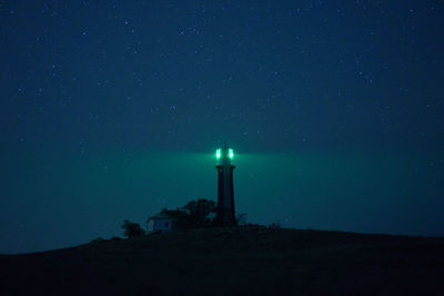 Lighthouse against sky at night