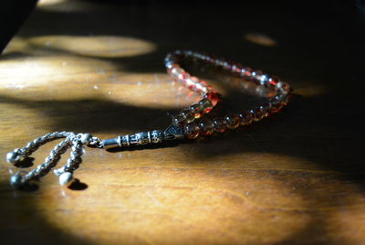 High angle view of prayer beads on wooden table