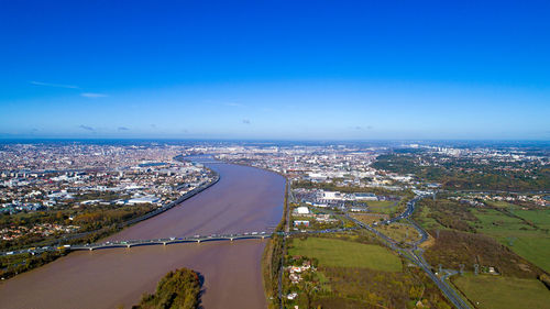 High angle view of road by sea against blue sky