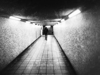 Rear view of man walking in underground walkway