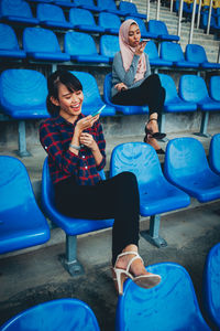 Full length of young couple sitting on chair