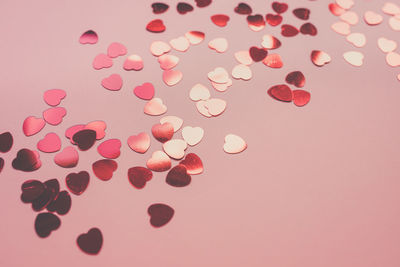 Romantic pink backround with red foil hearts