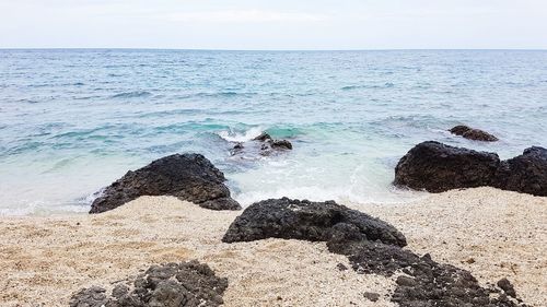 Scenic view of rocks on beach against sky
