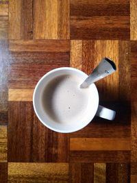 High angle view of coffee cup on wooden table