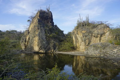 Scenic view of rock formation in lake against sky