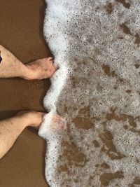 Low section of person standing on wet floor