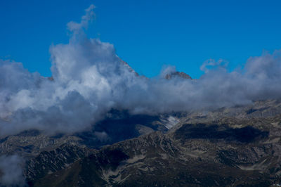 Scenic view of mountains against cloudy sky