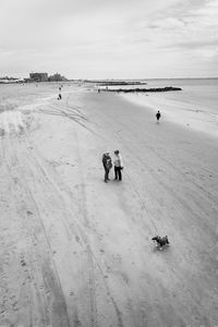 People walking on calm beach