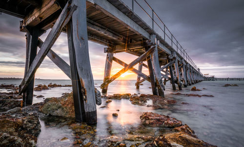 Pier over sea during sunset