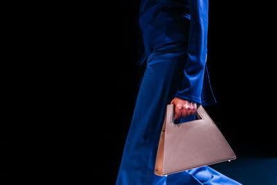 Woman wearing blue outfit and holding a stylish white minimalist handbag