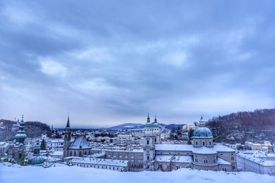 View of cityscape against cloudy sky