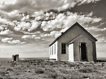 Abandoned house on field against sky