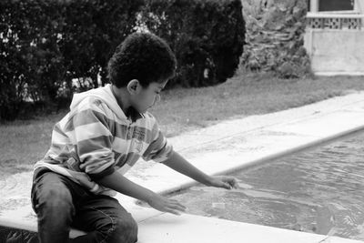 Boy sitting at swimming pool