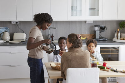 Family sitting at table and eating breakfast