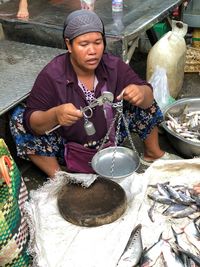 Full length of woman sitting at market