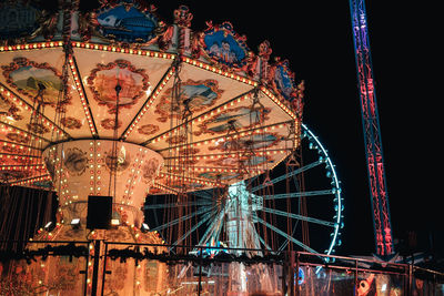 Low angle view of illuminated ferris wheel against sky at night