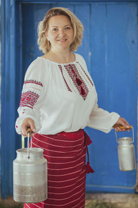 Hostess in embroidered clothes with milk can. retro photo of ancient ukrainian life