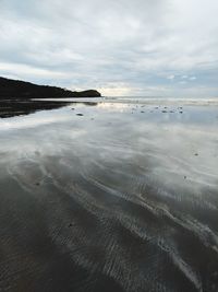 View of beach against cloudy sky