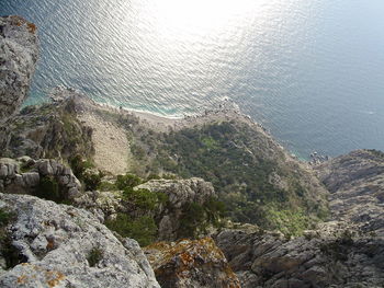 High angle view of sea by mountain against sky