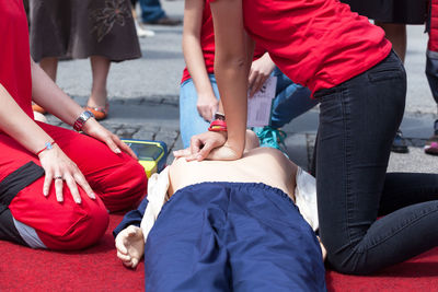 Midsection of people with cpr dummy during training