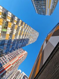 Low angle view of modern buildings against clear blue sky