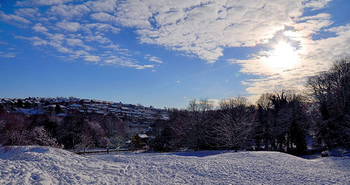 Scenic view of snow covered land against sky