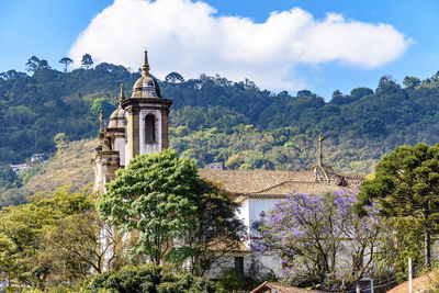 Traditional building by trees against sky