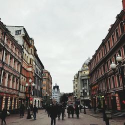 People on street in city against sky