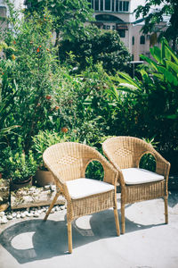 Empty chairs and table in yard against building
