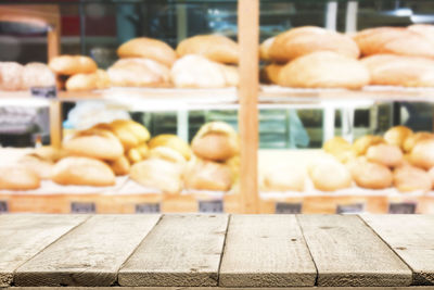Close-up of table against breads in shelves at store