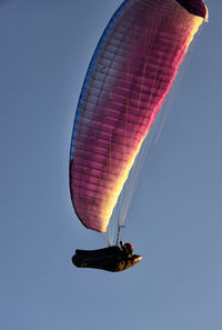 Low angle view of person paragliding against clear sky