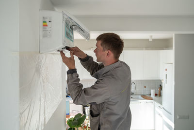 Man technician repairing apartment air conditioner