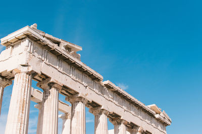 Low angle view of acropolis against clear sky during sunny day