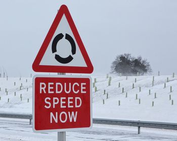 Close-up of road sign on snowcapped landscape